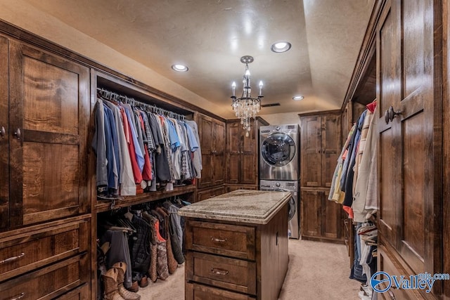 walk in closet with stacked washer and clothes dryer, light colored carpet, and visible vents