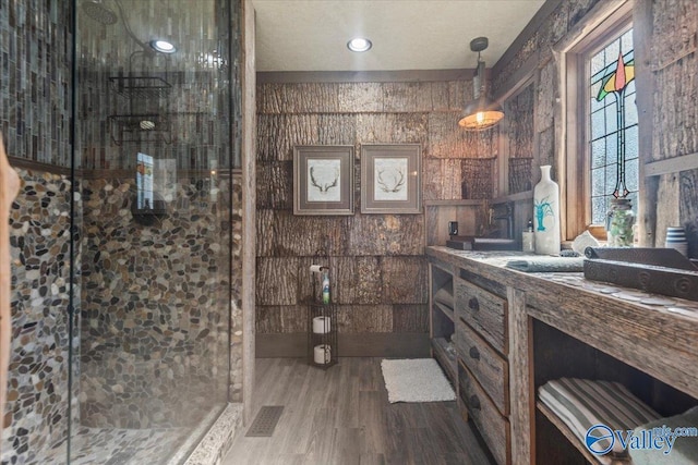 bathroom featuring a stall shower, visible vents, vanity, and wood finished floors