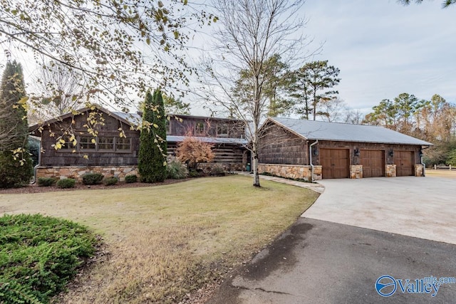 view of front of home featuring a garage, stone siding, a front lawn, and concrete driveway