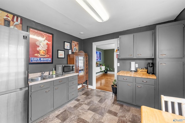 kitchen with gray cabinets, sink, and appliances with stainless steel finishes