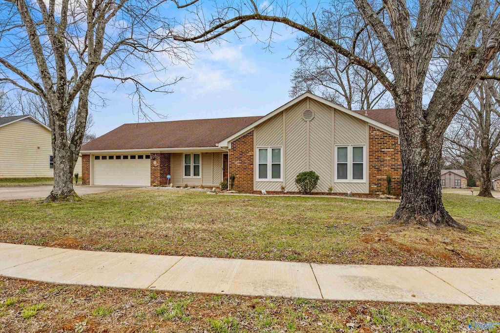 ranch-style house with a garage and a front lawn