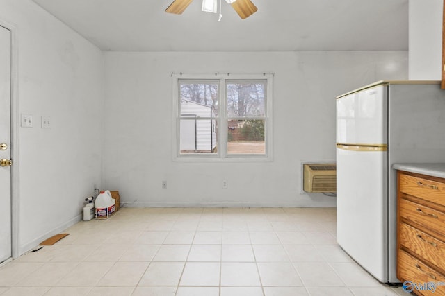 tiled empty room featuring a wall mounted air conditioner and ceiling fan