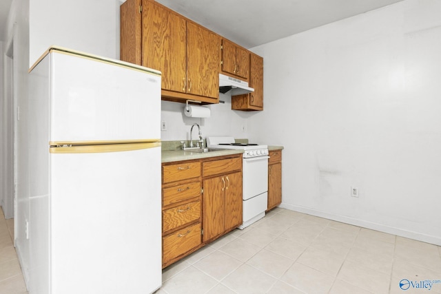 kitchen featuring light tile patterned floors, white appliances, and sink