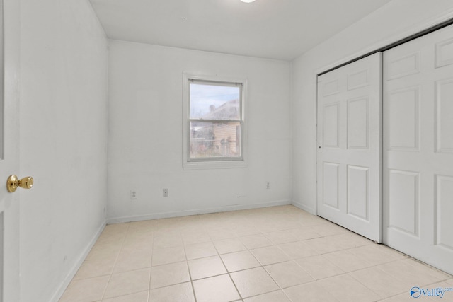 unfurnished bedroom with light tile patterned floors and a closet