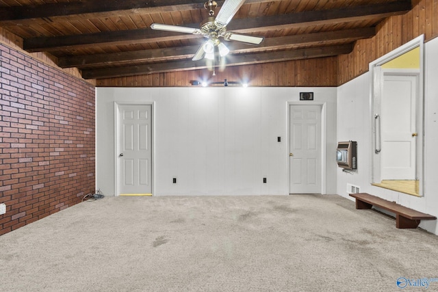 interior space with ceiling fan, carpet floors, brick wall, and wooden ceiling