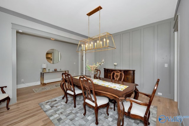 dining room with light hardwood / wood-style flooring and a notable chandelier