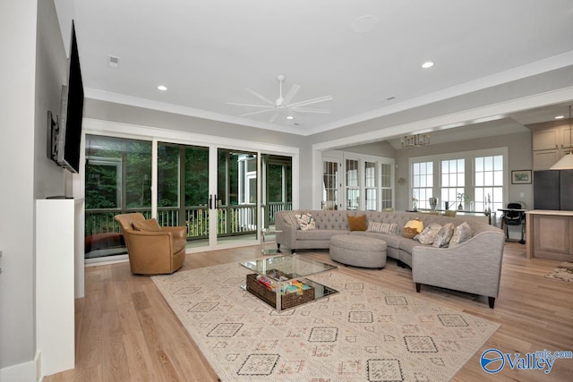 living room with crown molding, ceiling fan, light hardwood / wood-style flooring, and french doors