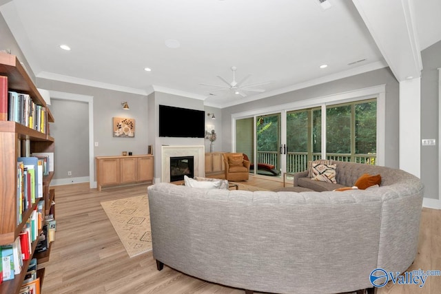 living room featuring light wood-type flooring, crown molding, and ceiling fan