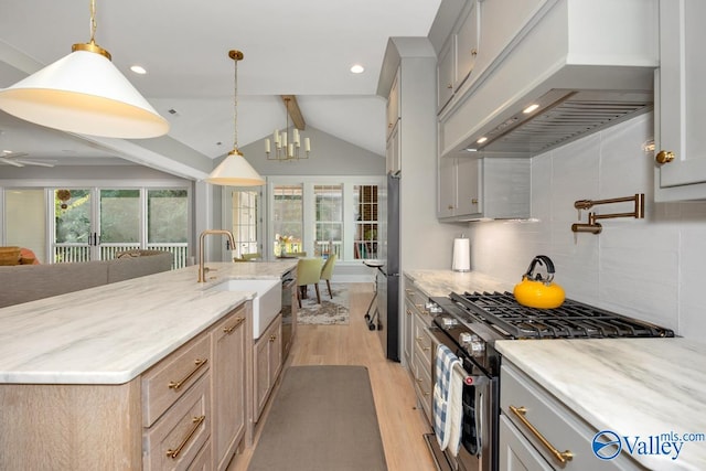 kitchen featuring pendant lighting, light wood-type flooring, custom range hood, range with two ovens, and backsplash