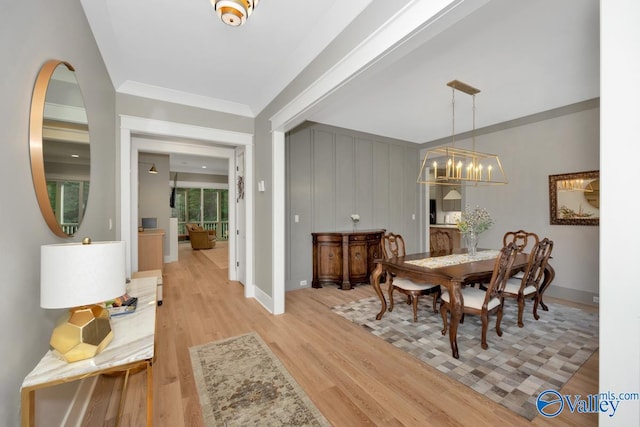 dining space featuring a notable chandelier and light wood-type flooring