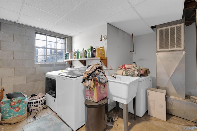 washroom featuring concrete block wall, laundry area, and washer and clothes dryer