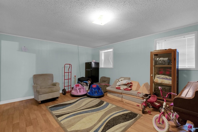 interior space featuring crown molding, a textured ceiling, and wood finished floors