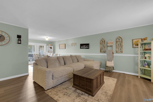 living area with crown molding, baseboards, and wood finished floors