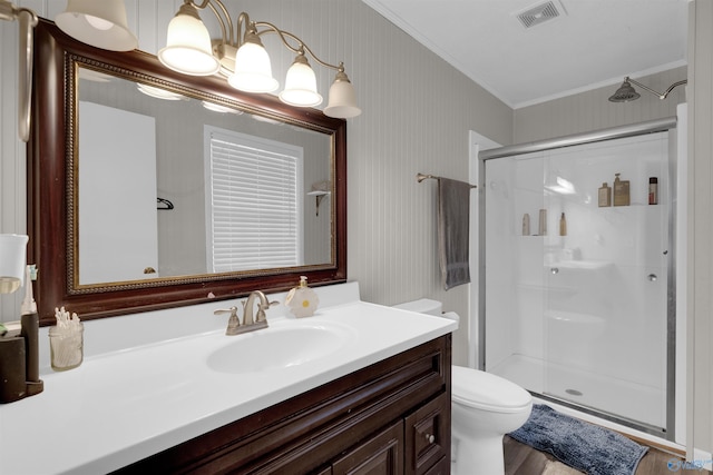 full bathroom featuring a stall shower, visible vents, toilet, ornamental molding, and vanity