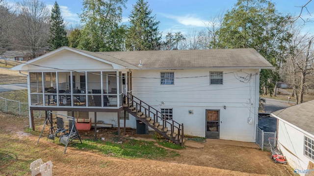 view of front facade featuring a sunroom, fence, and stairway