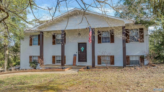 split foyer home with a porch and brick siding