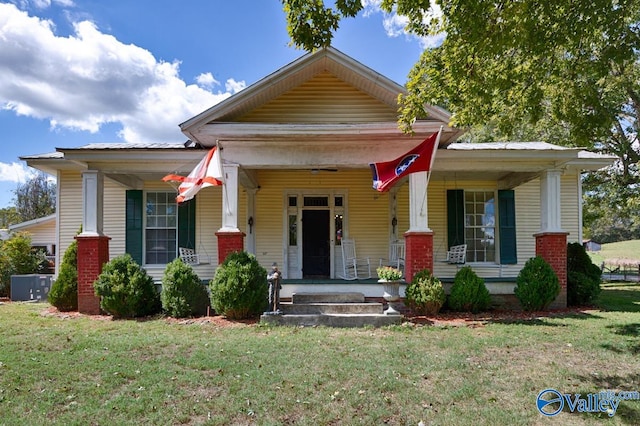 bungalow-style house featuring a porch, a front lawn, and central AC