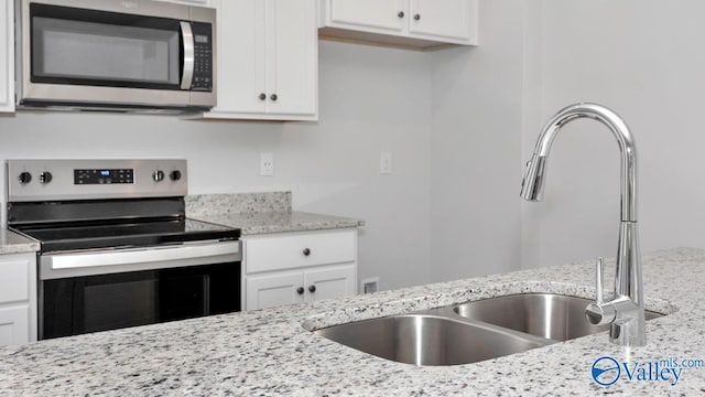 14 Moon Dr, Scottsboro, AL 35769 - kitchen featuring appliances with stainless steel finishes, a sink, white cabinets, and light stone countertops