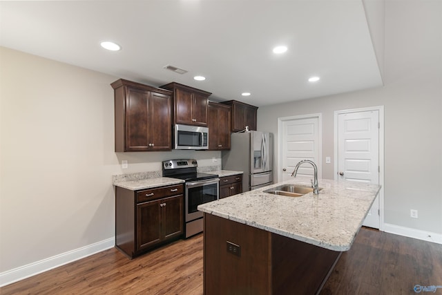 kitchen featuring dark brown cabinets, a sink, stainless steel appliances, and wood finished floors