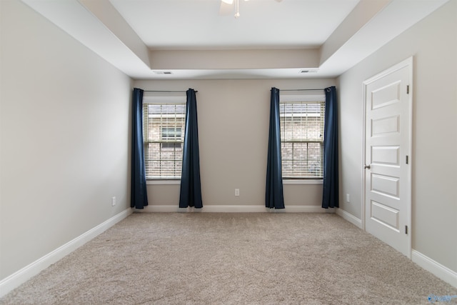 carpeted empty room featuring baseboards, a healthy amount of sunlight, and visible vents