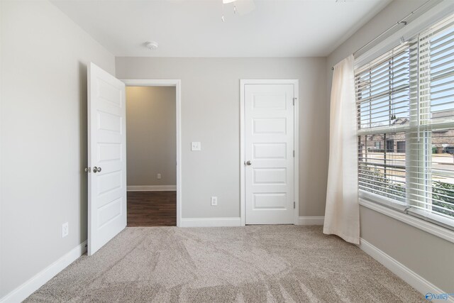 unfurnished bedroom with baseboards, carpet floors, and ceiling fan
