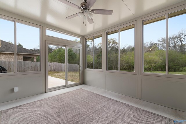 unfurnished sunroom featuring a ceiling fan and a wealth of natural light