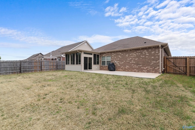 back of property featuring a lawn, a sunroom, a fenced backyard, and a patio