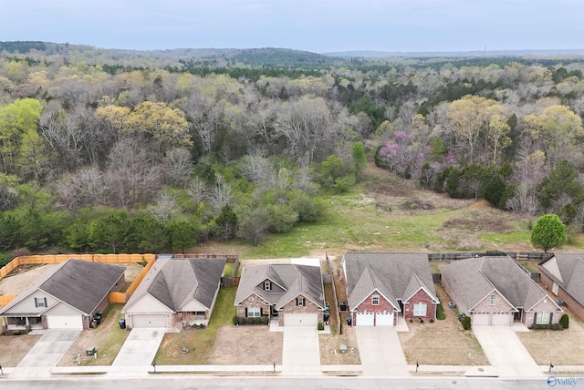 drone / aerial view featuring a residential view and a forest view