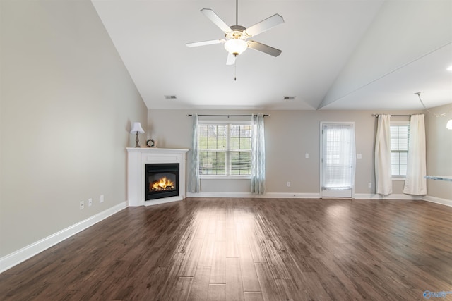 unfurnished living room featuring dark wood-style floors, a glass covered fireplace, ceiling fan, and plenty of natural light