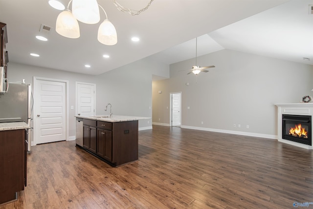 kitchen with visible vents, stainless steel appliances, dark brown cabinetry, open floor plan, and a glass covered fireplace
