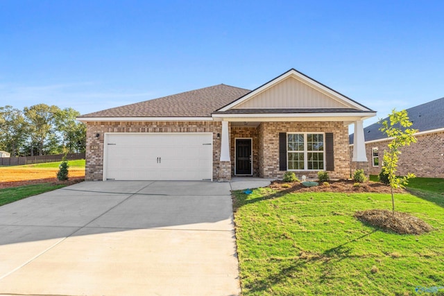 craftsman-style house featuring brick siding, a front yard, fence, a garage, and driveway