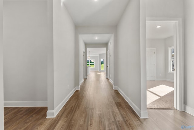 corridor featuring baseboards and wood finished floors