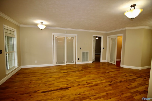 unfurnished room featuring ornamental molding and hardwood / wood-style flooring