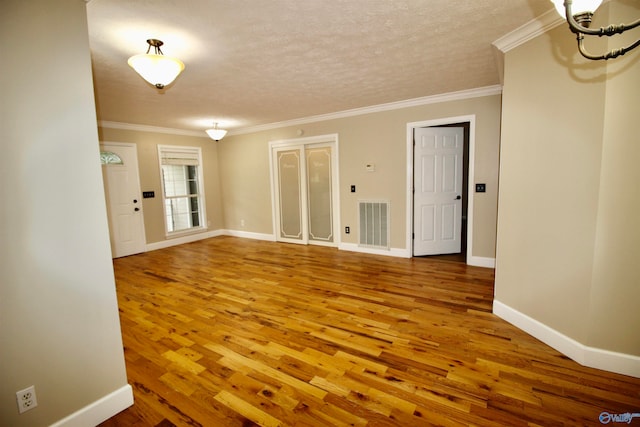 spare room with ornamental molding, a textured ceiling, and hardwood / wood-style floors