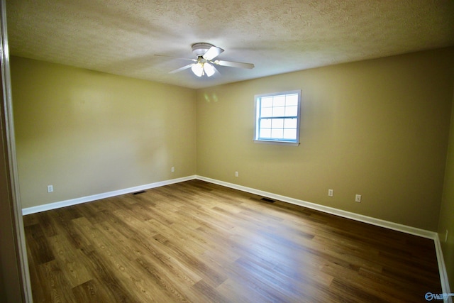 unfurnished room with a textured ceiling, wood-type flooring, and ceiling fan