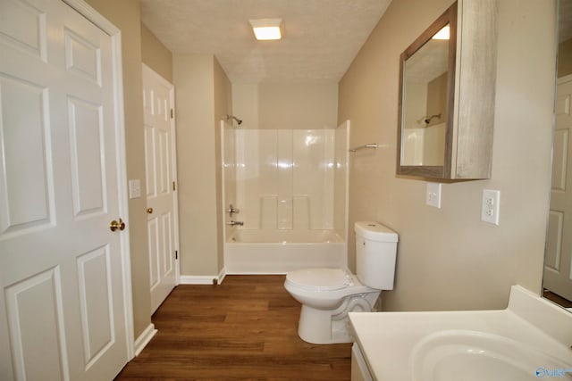 full bathroom featuring washtub / shower combination, a textured ceiling, toilet, vanity, and wood-type flooring