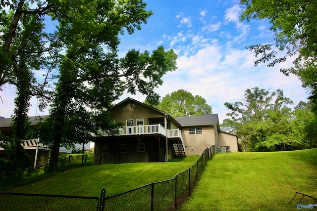 back of property with a yard and a wooden deck