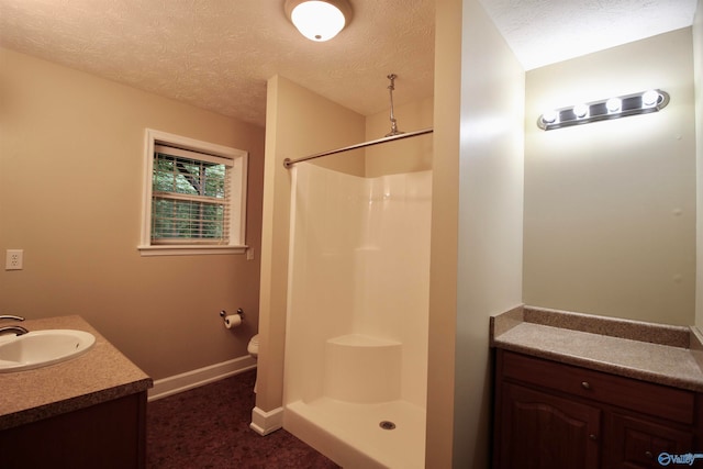 bathroom with walk in shower, toilet, vanity, and a textured ceiling