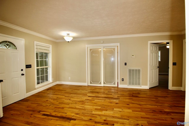 foyer entrance with ceiling fan, wood-type flooring, a textured ceiling, and ornamental molding