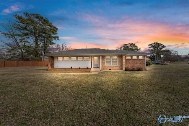 ranch-style house featuring crawl space, brick siding, fence, and a front lawn