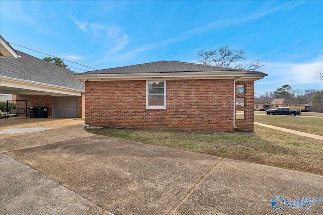 view of property exterior featuring a garage, brick siding, a lawn, and driveway