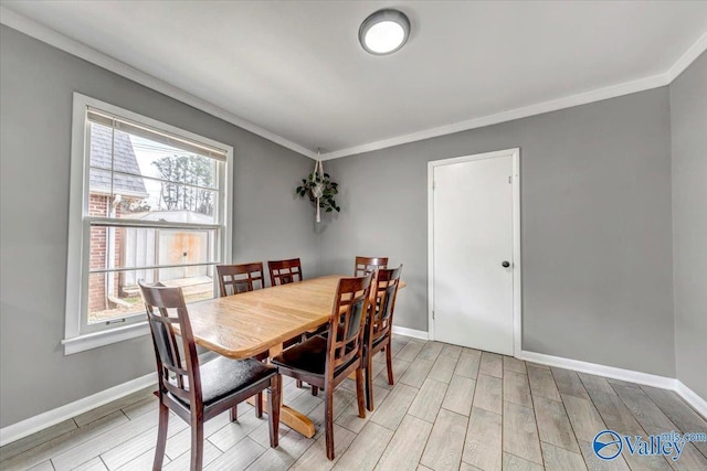 dining room with baseboards, crown molding, and wood tiled floor