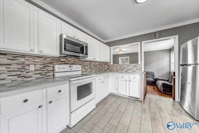 kitchen with stainless steel appliances, tasteful backsplash, light countertops, and white cabinetry