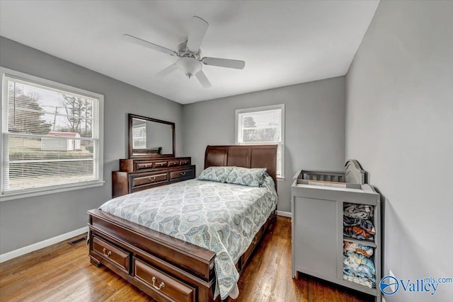 bedroom with visible vents, ceiling fan, baseboards, and wood finished floors