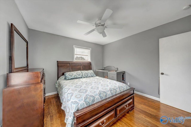 bedroom featuring a ceiling fan, baseboards, and wood finished floors