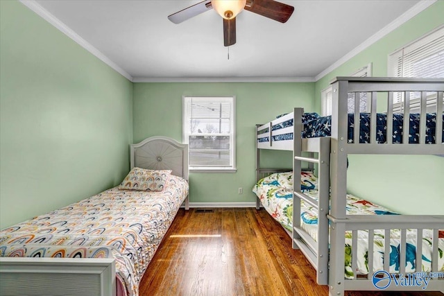 bedroom featuring baseboards, wood finished floors, a ceiling fan, and crown molding