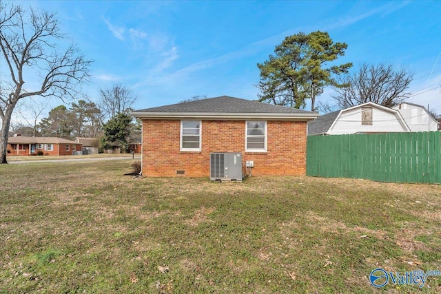 back of house featuring crawl space, fence, cooling unit, and brick siding