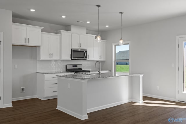 kitchen featuring sink, stainless steel appliances, an island with sink, and white cabinetry