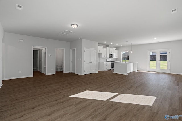 unfurnished living room featuring dark hardwood / wood-style flooring and french doors