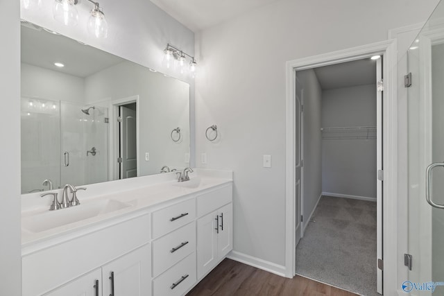 bathroom with hardwood / wood-style flooring, a shower with door, and vanity